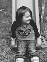 Cute baby girl sitting on slide at park