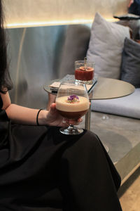 Midsection of woman holding coffee at home