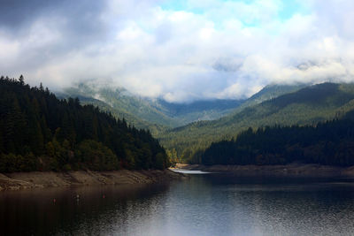 Scenic view of river and mountains against sky