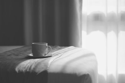 A cup of coffee on the bed  with the morning light shining through the window