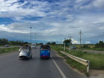 Empty road against cloudy sky