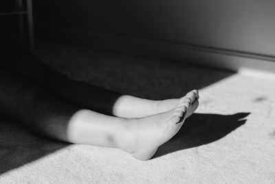 Low section of woman relaxing on floor at home