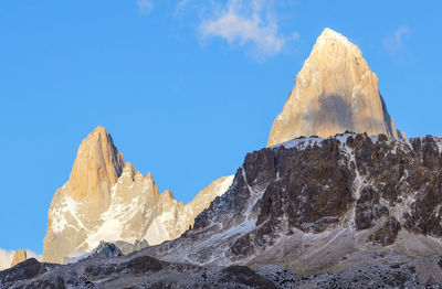 Scenic view of snowcapped mountains against blue sky