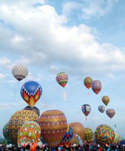 Low angle view of hot air balloons flying against sky