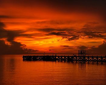 Scenic view of sea against dramatic sky during sunset