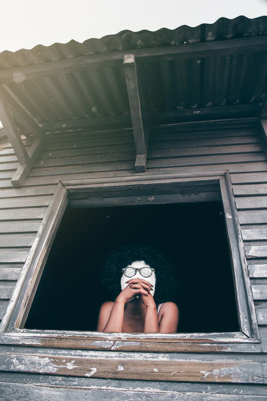 CLOSE-UP OF YOUNG WOMAN AGAINST BUILDING