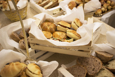 Sandwiches on paper in wooden box on table