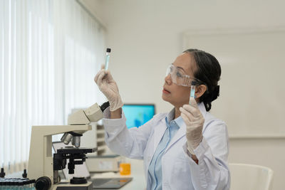 Female doctor examining chemical in laboratory