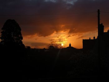 Silhouette buildings against sky during sunset