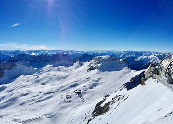 Scenic view of snowcapped mountains against blue sky