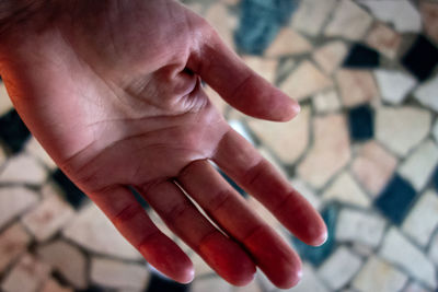 Cropped hand of person against tiled floor