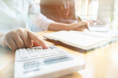 Close-up of woman using laptop on table