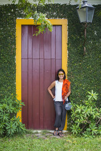 Woman posing in front of door with yellow frame in paraty / brazil