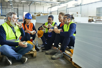 Workers in factory having lunch break together