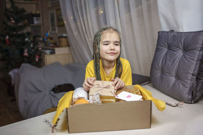 Portrait of girl sitting on sofa at home