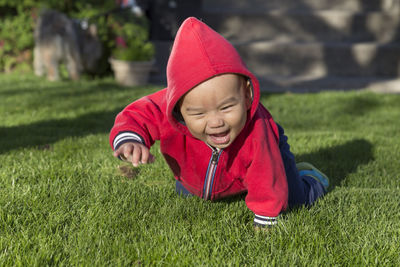 Cute baby boy with mouth open crawling on grass land