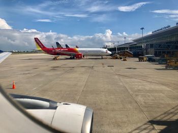 Airplane on airport runway against sky