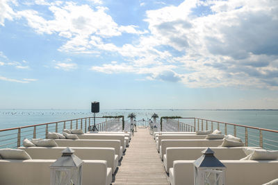 Chairs on beach against sky