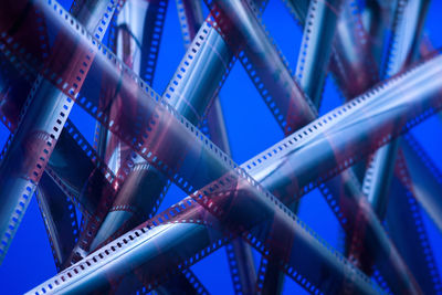 Full frame shot of tangled film reels against blue background