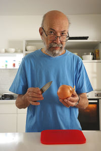 Portrait of senior man holding apple