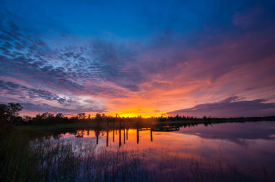 Scenic view of lake against romantic sky at sunset