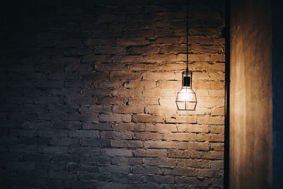 Full frame shot of illuminated light bulb on brick wall