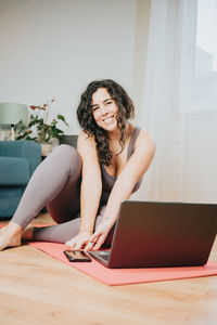 Portrait of overweight woman sitting by laptop at home