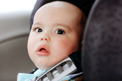 Sweet little baby boy in the car in baby safety seat