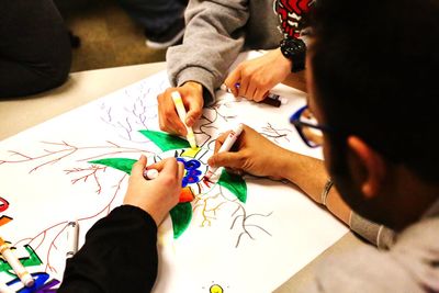 Close-up of people drawing on paper