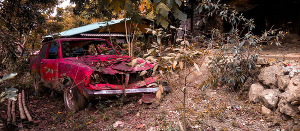 View of abandoned car on field