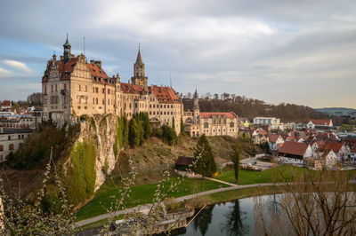 Buildings in town against cloudy sky