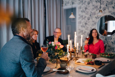 Mature friends enjoying dinner party at home