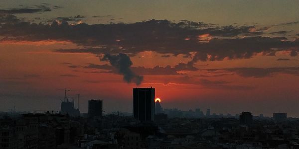 Buildings in city against sky at sunset