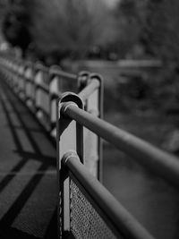 Black and white image of bridge in daylight with dark shadows contrasting against highlight rails.