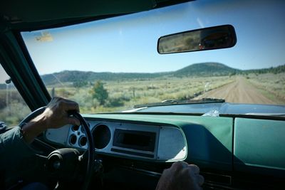 Cropped hands of man driving car