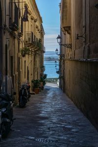 Narrow street amidst buildings against sky