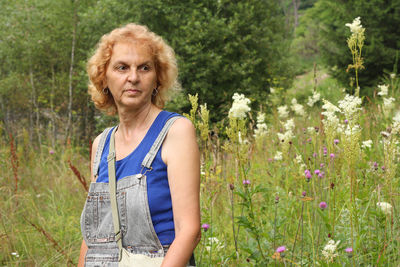 Portrait of woman standing against plants