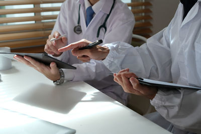 Midsection of doctor examining patient in clinic