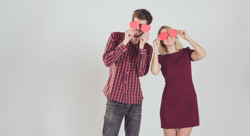 Young couple standing against white background