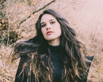 Portrait of young woman against tree