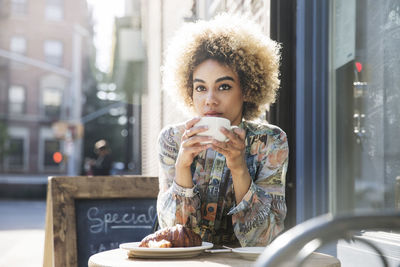 Portrait of young woman drinking coffee cup