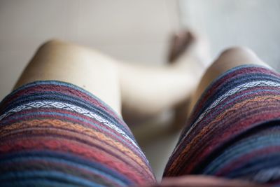 Low section of person sitting on multi colored pencils