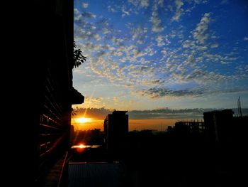 Silhouette of building against sunset sky