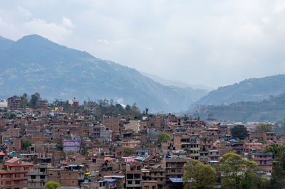 Townscape by mountains against sky