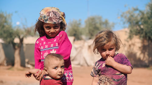 Portrait of siblings playing with daughter