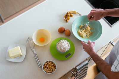 Overhead view of a young man making cookies at the kitchen