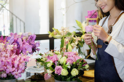 Midsection of florist holding flower at shop