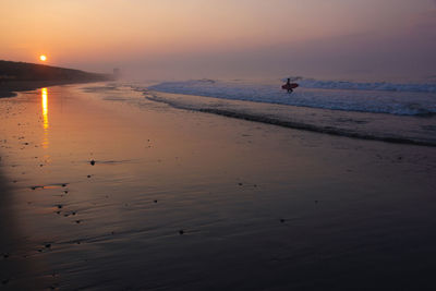 Scenic view of beach against sky during sunset