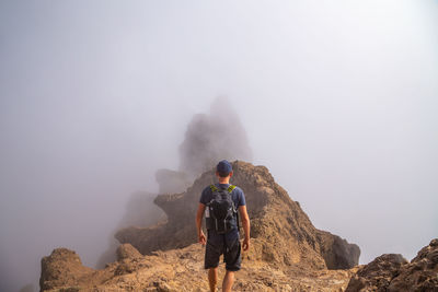 Rear view of people on rock looking at mountains