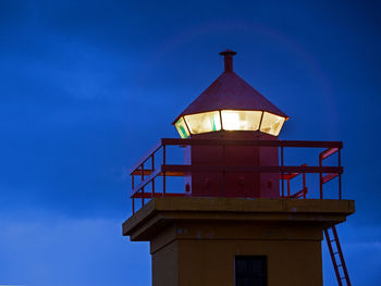 Closeup of the top of an orange lighthouse, iceland
